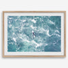 Fine art aerial photography print of a lone surfer floating on a surfboard amidst turquoise ocean waves with intricate white foam patterns.