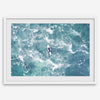 Fine art aerial photography print of a lone surfer floating on a surfboard amidst turquoise ocean waves with intricate white foam patterns.