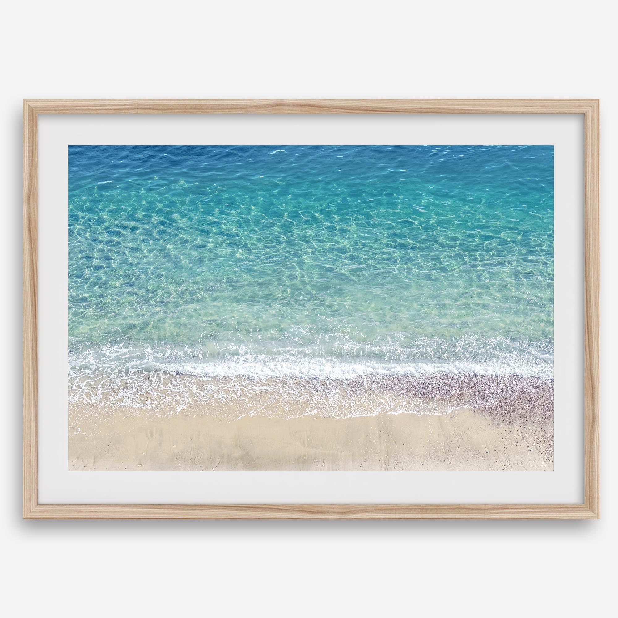 This fine art aerial beach print showcases the mesmerizing colors of the ocean in vivid detail. From the deep blue depths to the vibrant greenish turquoise blue, transitioning to the golden sandy beach and the crashing white surf.