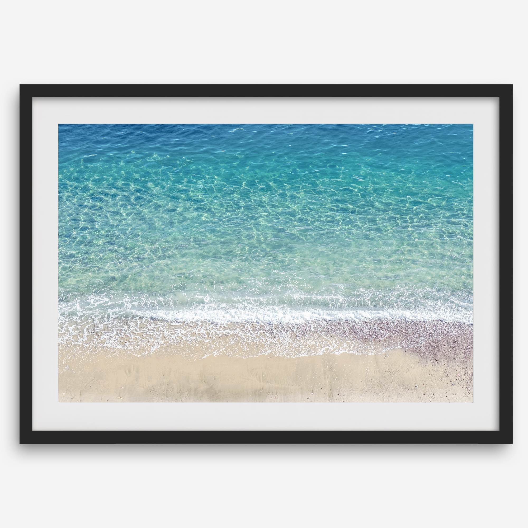 This fine art aerial beach print showcases the mesmerizing colors of the ocean in vivid detail. From the deep blue depths to the vibrant greenish turquoise blue, transitioning to the golden sandy beach and the crashing white surf.