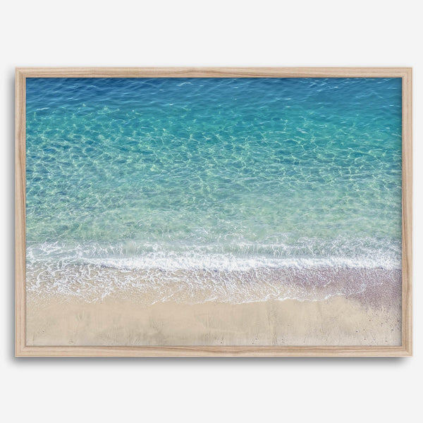 This fine art aerial beach print showcases the mesmerizing colors of the ocean in vivid detail. From the deep blue depths to the vibrant greenish turquoise blue, transitioning to the golden sandy beach and the crashing white surf.