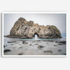 Fine art print showcasing a magnificent rock formation framing the horizon and crashing waves, with scattered rocks adding texture. Captivating and soothing, this print is a timeless addition to any space, evoking relaxation and awe-inspiring beauty.