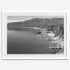 A fine art black and white Lake Tahoe print showcasing docks and boats nested on the lake waters on the left, while the beachfront, nestled against a backdrop of a lush forest and majestic mountain, paints a picturesque scene on the right.