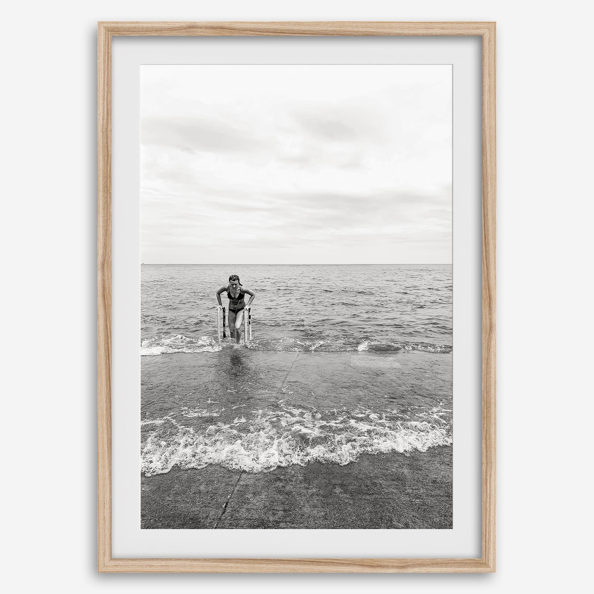 A black and white fine art lake beach print of a beach in Chicago on the coast of Lake Michigan showcasing a woman bathing in the lake. The classic modern look of the print is sure to impress when hung on your walls.