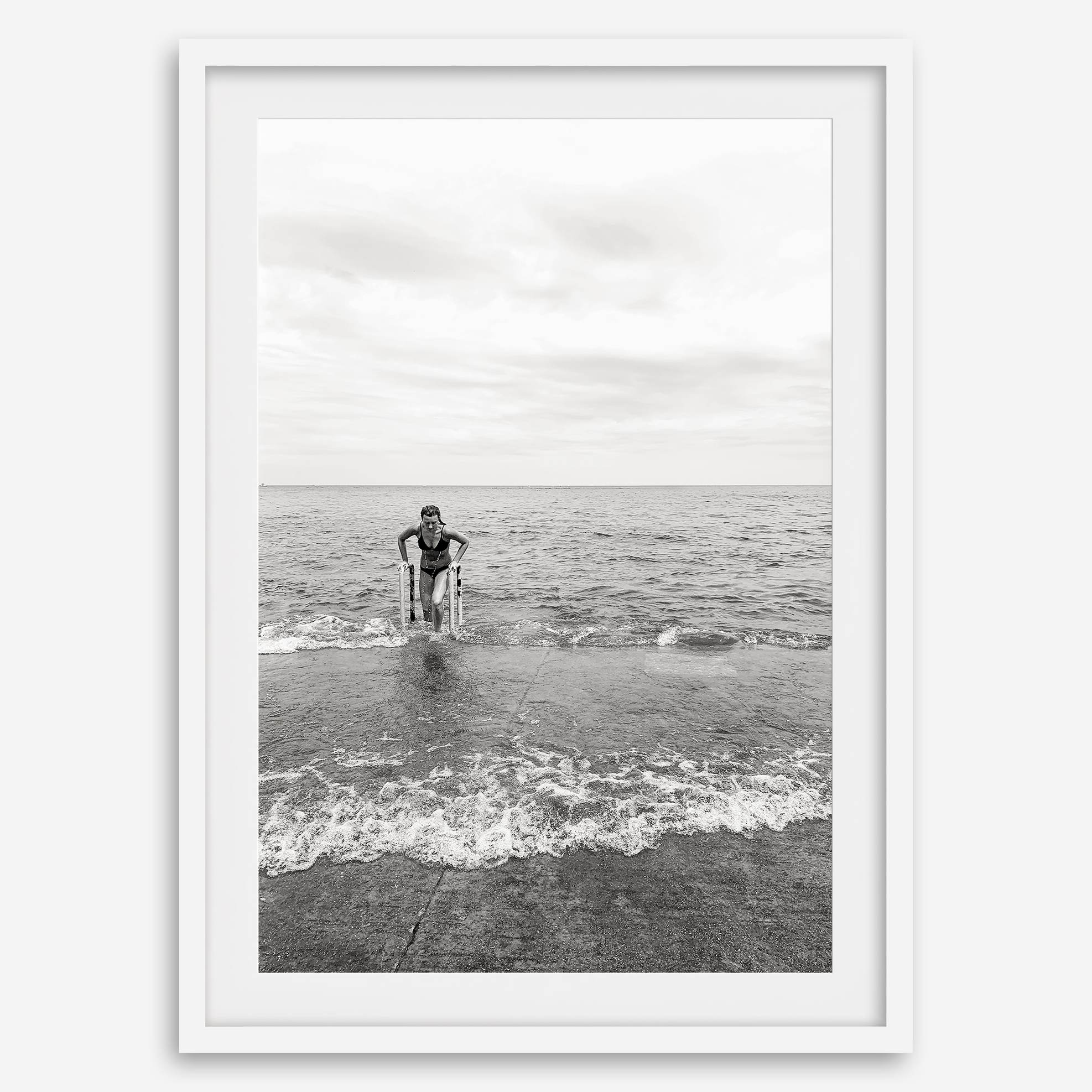A black and white fine art lake beach print of a beach in Chicago on the coast of Lake Michigan showcasing a woman bathing in the lake. The classic modern look of the print is sure to impress when hung on your walls.