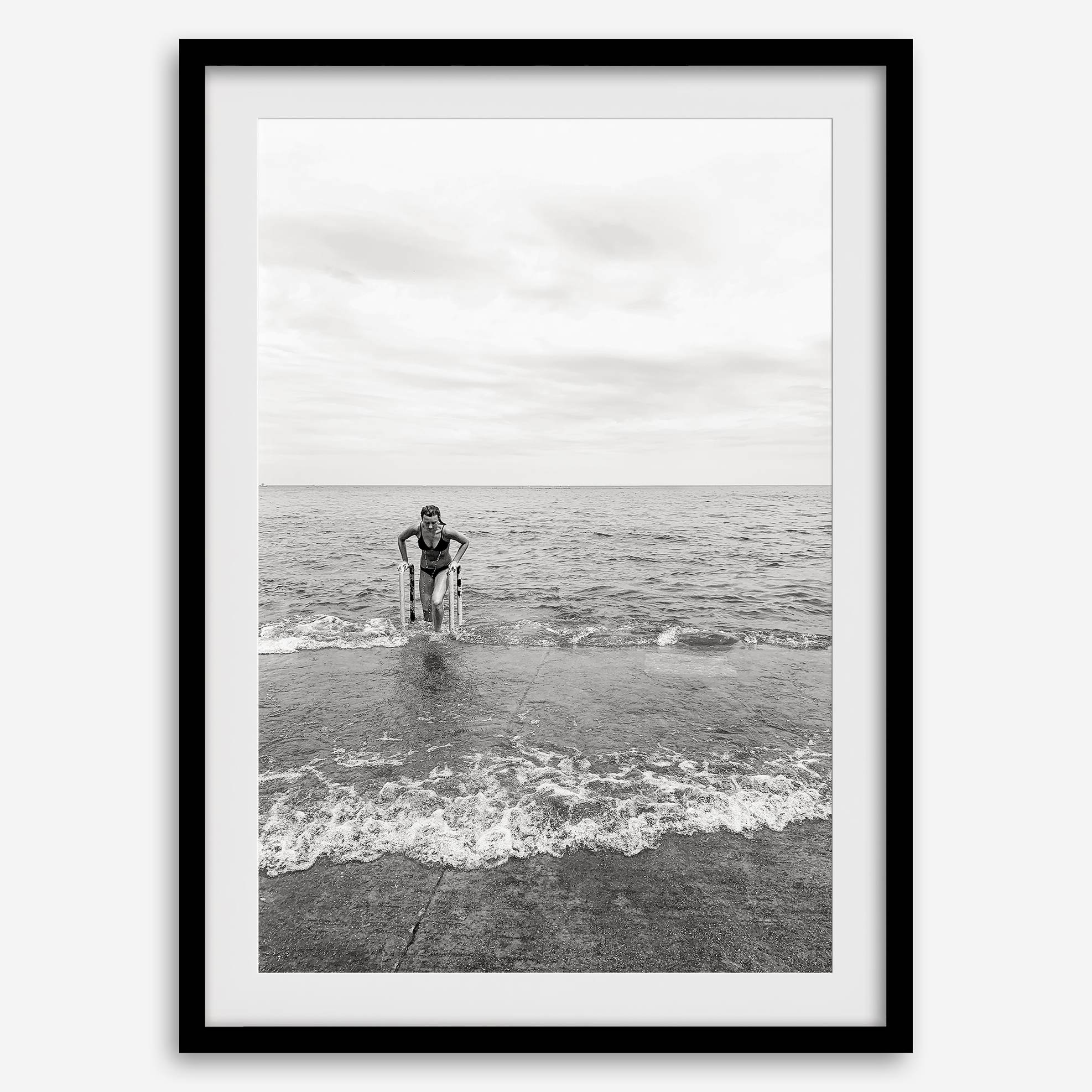 A black and white fine art lake beach print of a beach in Chicago on the coast of Lake Michigan showcasing a woman bathing in the lake. The classic modern look of the print is sure to impress when hung on your walls.