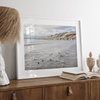 Surfers paddling near Pismo Beach captured in a fine art photography print with coastal cliffs and serene ocean views.