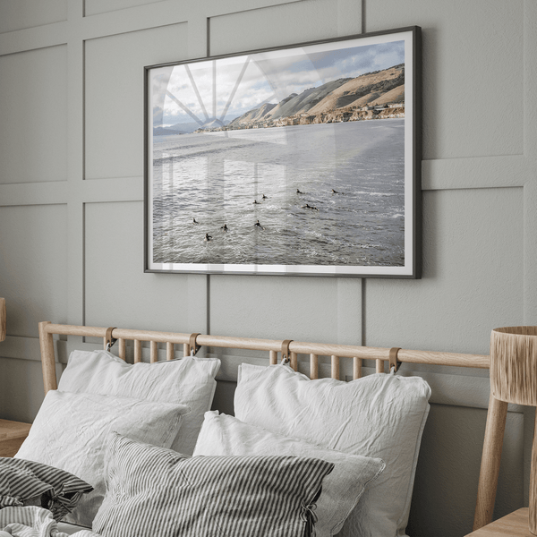 Surfers paddling near Pismo Beach captured in a fine art photography print with coastal cliffs and serene ocean views.