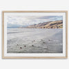 Surfers paddling near Pismo Beach captured in a fine art photography print with coastal cliffs and serene ocean views.