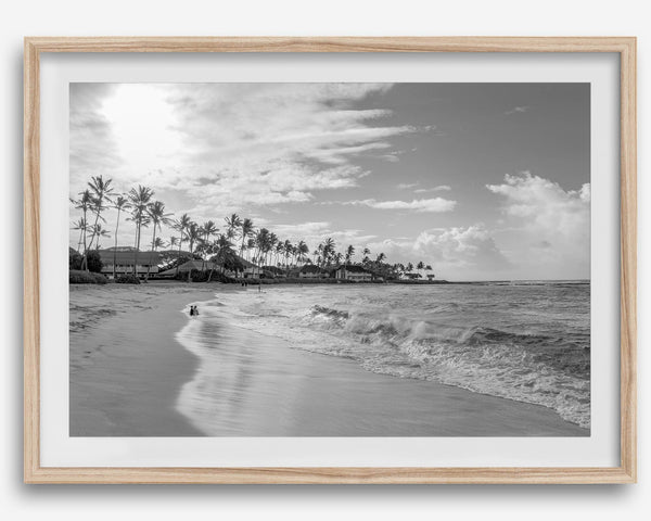 Black and white tropical wall art featuring a serene sunrise on a beach in Kauai, Hawaii with palm trees