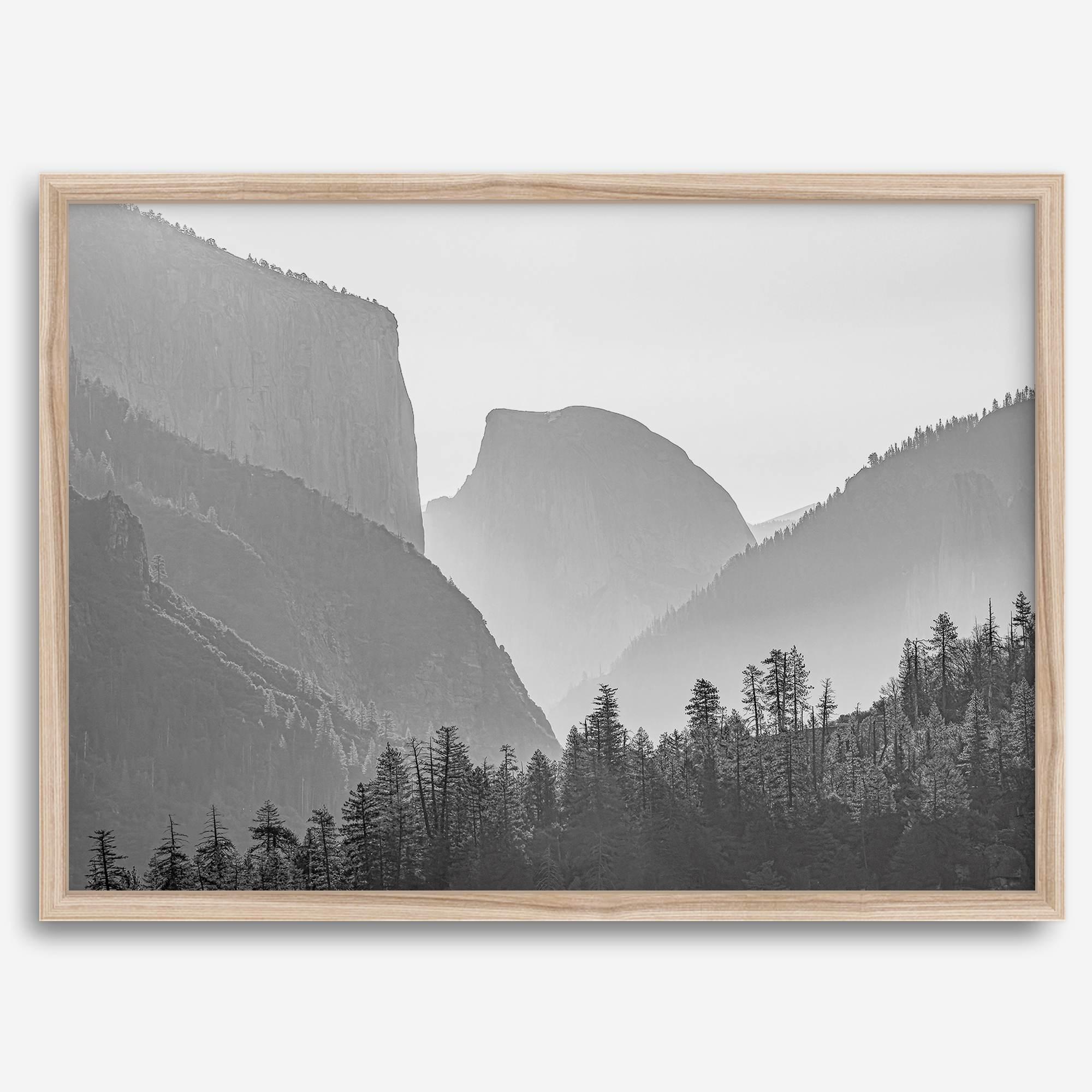 A black and white photography wall art of Yosemite Valley at sunset, featuring the iconic Half Dome and El Capitan bathed in dramatic light and shadow. Perfect for nature lovers and art enthusiasts.