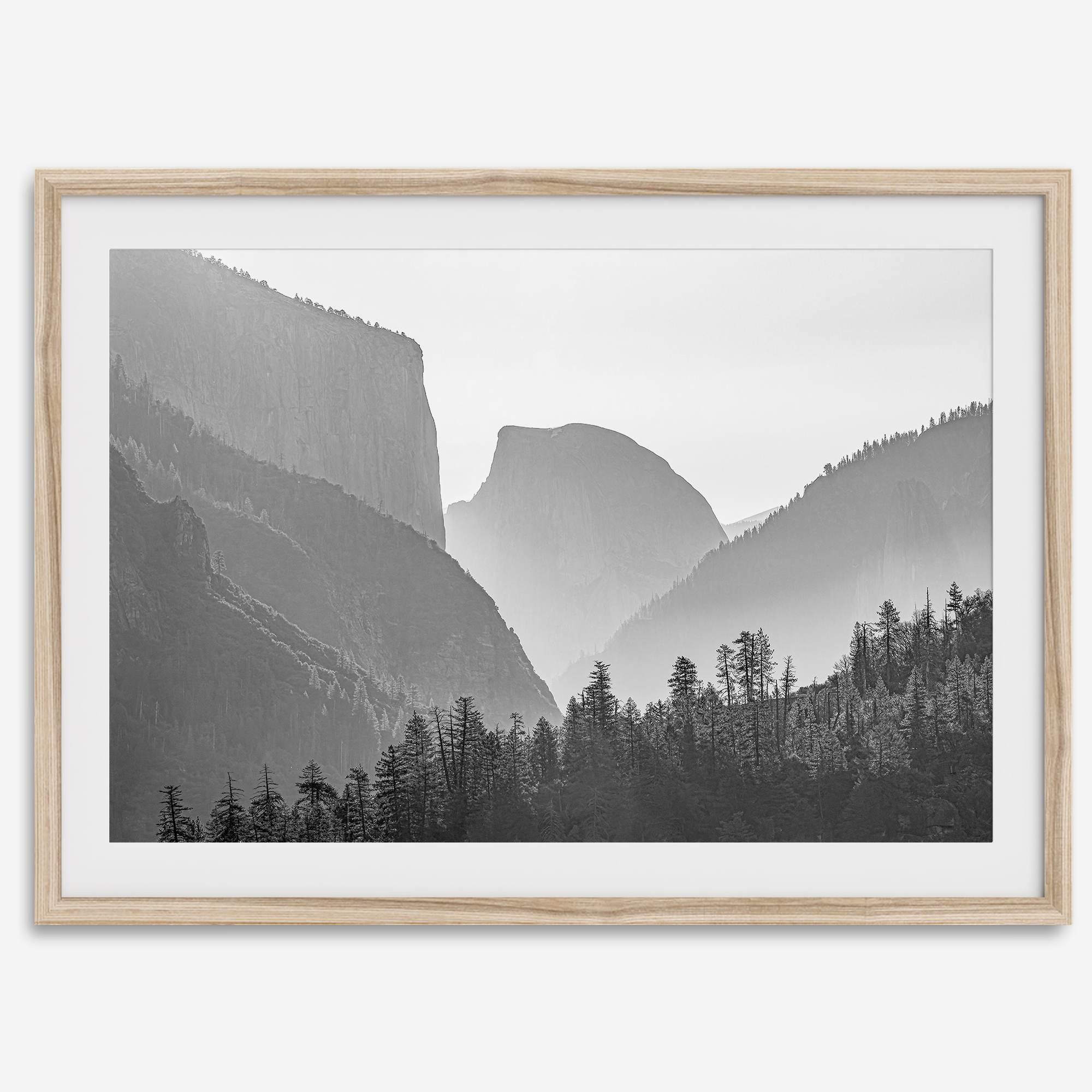 A black and white photography wall art of Yosemite Valley at sunset, featuring the iconic Half Dome and El Capitan bathed in dramatic light and shadow. Perfect for nature lovers and art enthusiasts.