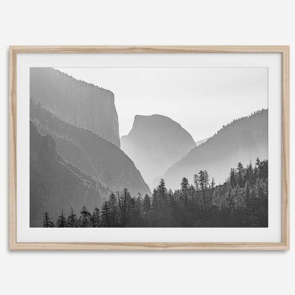 A black and white photography wall art of Yosemite Valley at sunset, featuring the iconic Half Dome and El Capitan bathed in dramatic light and shadow. Perfect for nature lovers and art enthusiasts.