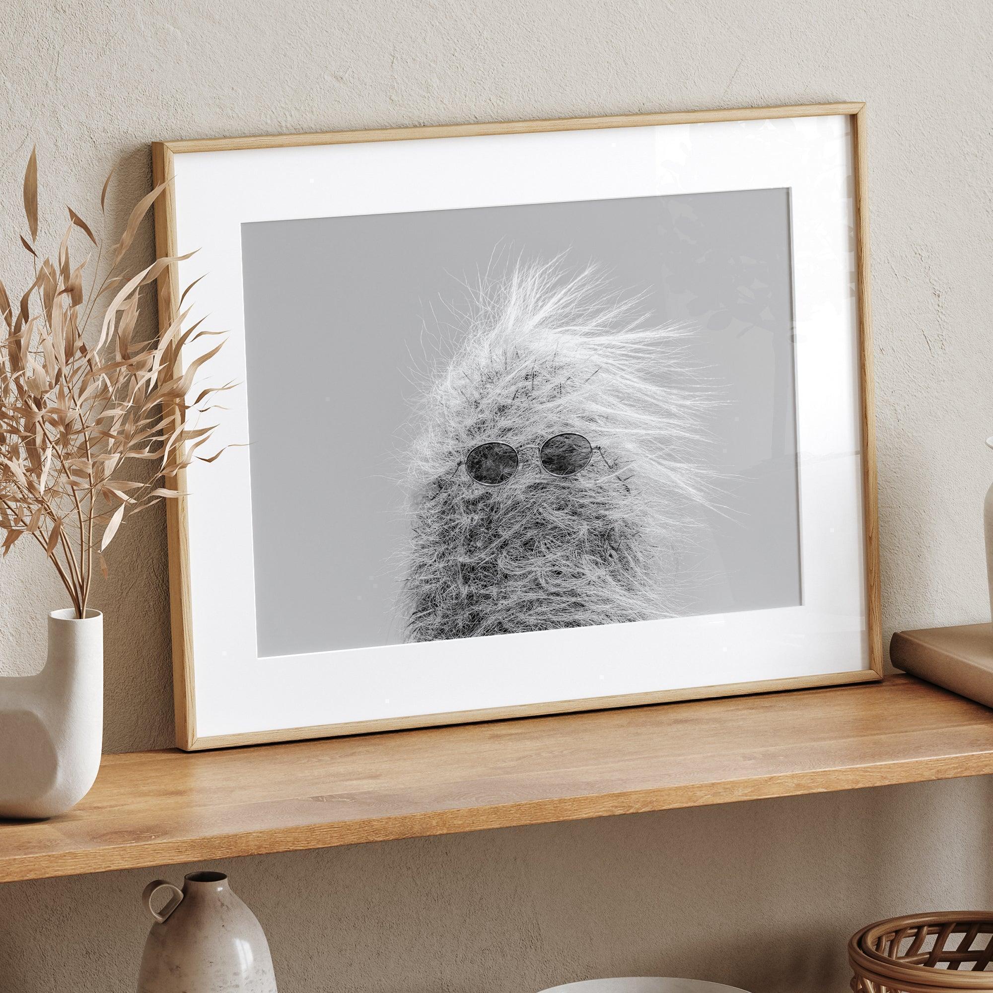 Black-and-white cactus print featuring a windswept cool cactus with sunglasses in a minimalist desert setting.