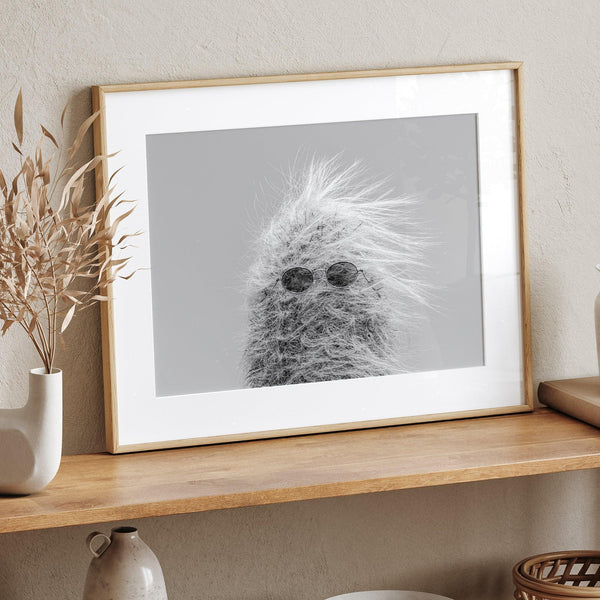 Black-and-white cactus print featuring a windswept cool cactus with sunglasses in a minimalist desert setting.