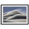 Fine art photo of Mesquite Flat Sand Dunes in Death Valley at golden hour. Windblown sand creates textured patterns across the immense dunes, bathed in warm light.