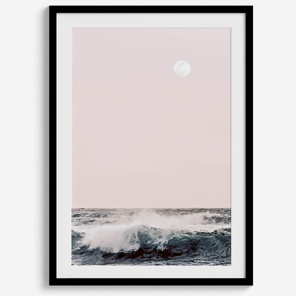 This extraordinary ocean wall art captures a mesmerizing moment when a powerful wave crashes while the sunset gentle blush pink hues fill the sky and a large full moon rises majestically in the backdrop.