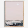 This extraordinary ocean wall art captures a mesmerizing moment when a powerful wave crashes while the sunset gentle blush pink hues fill the sky and a large full moon rises majestically in the backdrop.