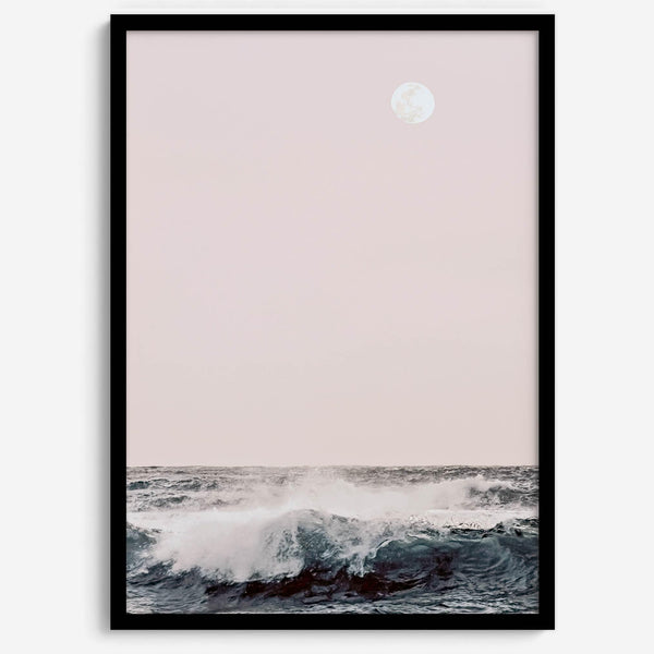 This extraordinary ocean wall art captures a mesmerizing moment when a powerful wave crashes while the sunset gentle blush pink hues fill the sky and a large full moon rises majestically in the backdrop.
