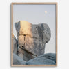Minimalist desert moon wall art featuring massive sunlit rock formations beneath a pale moon and soft gray sky. Southwest fine art photography.