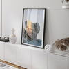 Minimalist desert moon wall art featuring massive sunlit rock formations beneath a pale moon and soft gray sky. Southwest fine art photography.