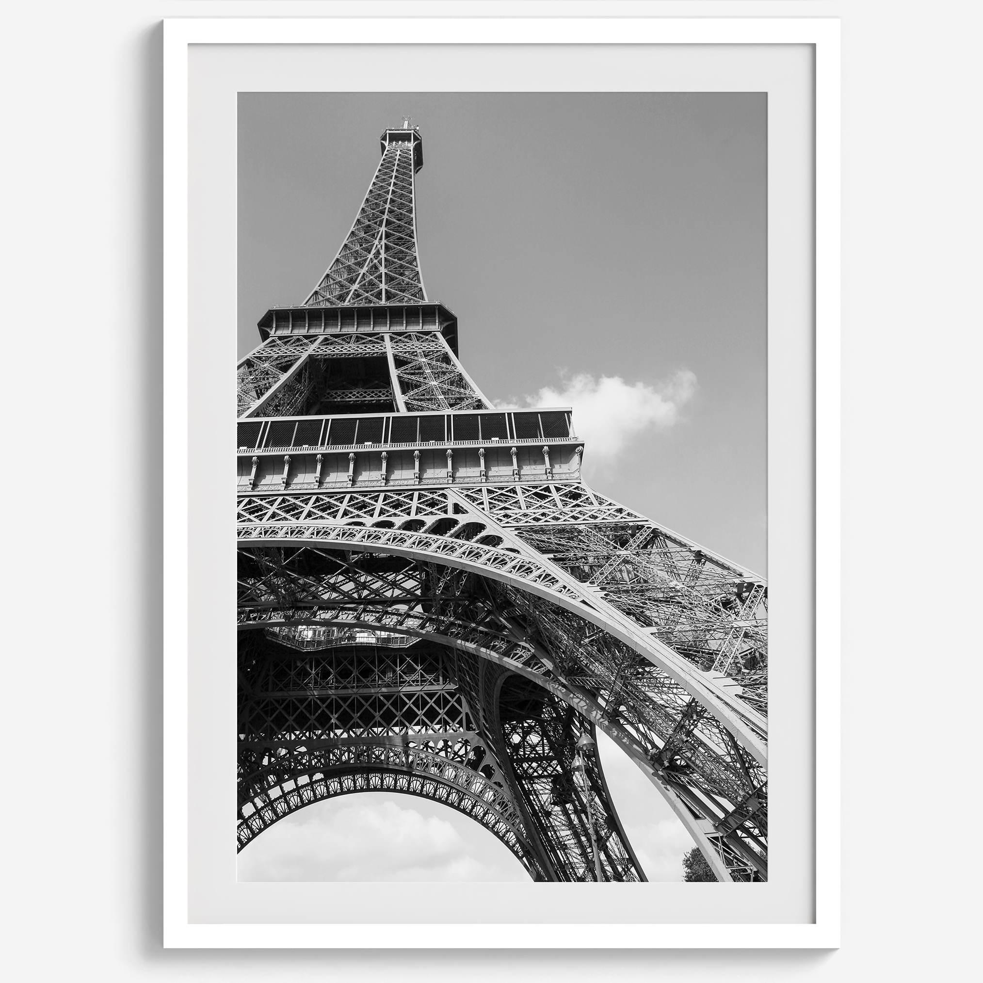 A fine art Eiffel Tower black and white print. This Paris theme wall art showcases a unique wide-angle view from the bottom of the tower, creating a modern, trendy fine art photography to hang on your walls.