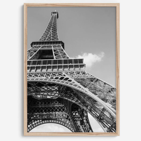 A fine art Eiffel Tower black and white print. This Paris theme wall art showcases a unique wide-angle view from the bottom of the tower, creating a modern, trendy fine art photography to hang on your walls.