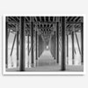 A large fine art abstract black and white beach pier print This stunning beach wall art shows the symmetric structure of the pier with the ocean water gently caressing the pier and beach.