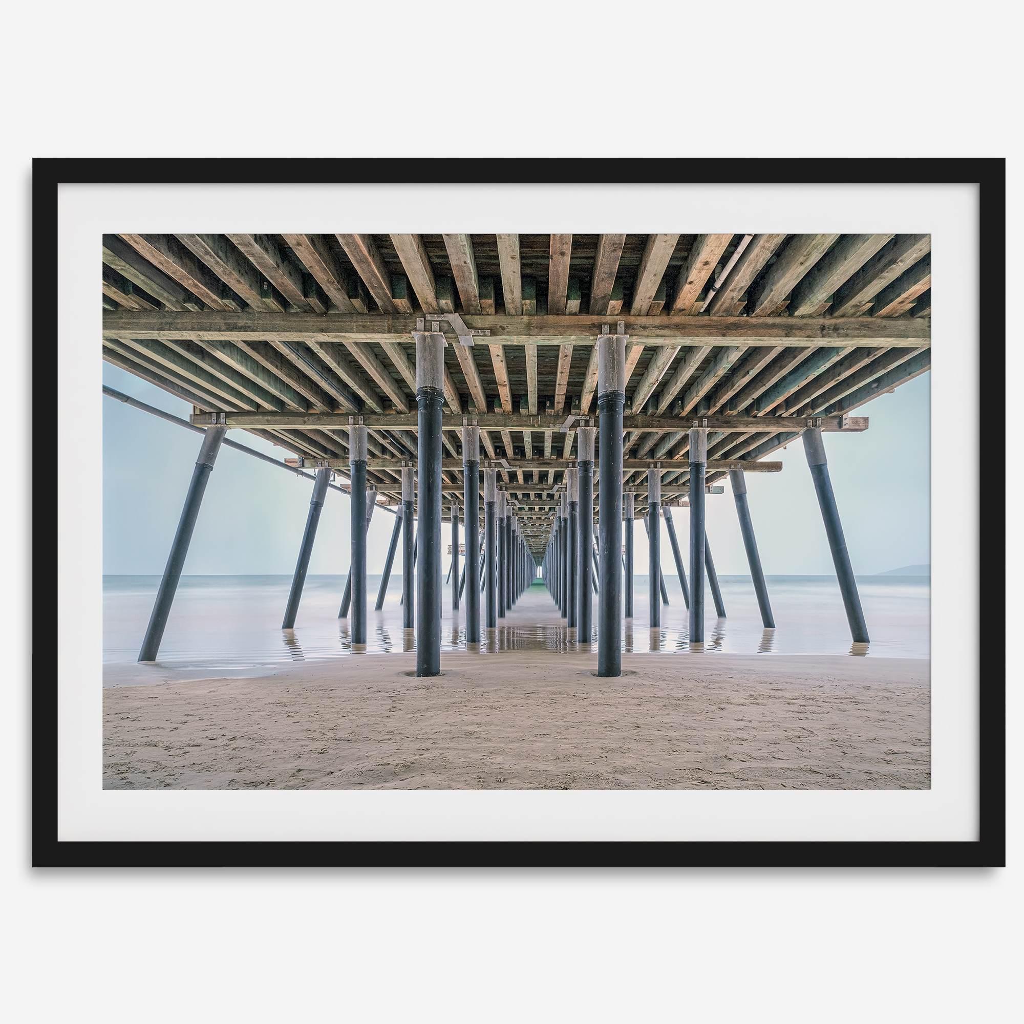 A fine art boho style beach photography print featuring a view from below Pismo Beach Pier.