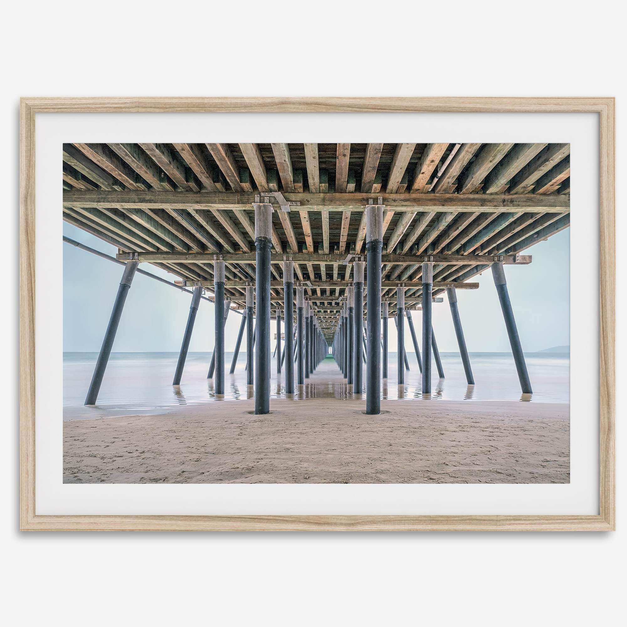 A fine art boho style beach photography print featuring a view from below Pismo Beach Pier.