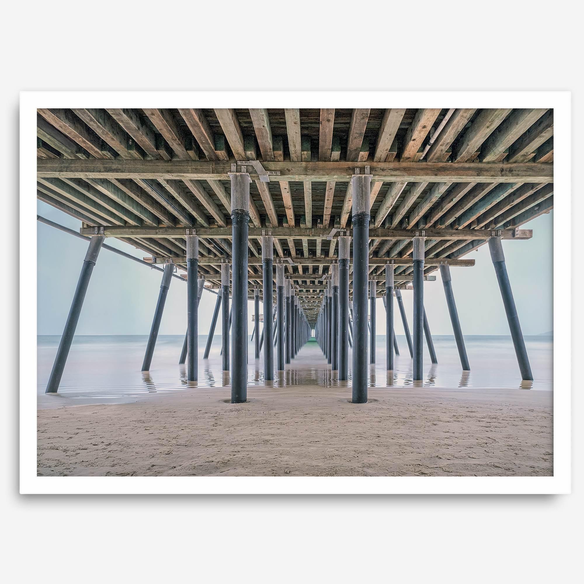 A fine art boho style beach photography print featuring a view from below Pismo Beach Pier.