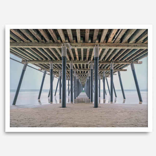 A fine art boho style beach photography print featuring a view from below Pismo Beach Pier.