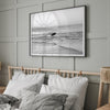 A fine art photography print capturing a female surfer walking back from the ocean at sunset with waves breaking in the foreground, capturing the end of a surf session.