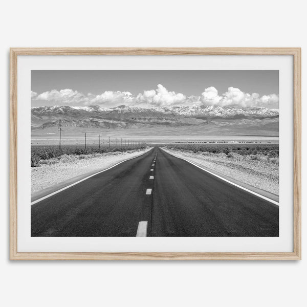 This stunning piece of black and white desert wall art will take your breath away. A beautifully framed picture of a Death Valley National Park road leading towards the snow-covered mountains at the end of the desert.