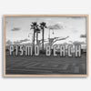 Black and white photo of the Pismo Beach street sign with palm trees and boardwalk – fine art coastal print