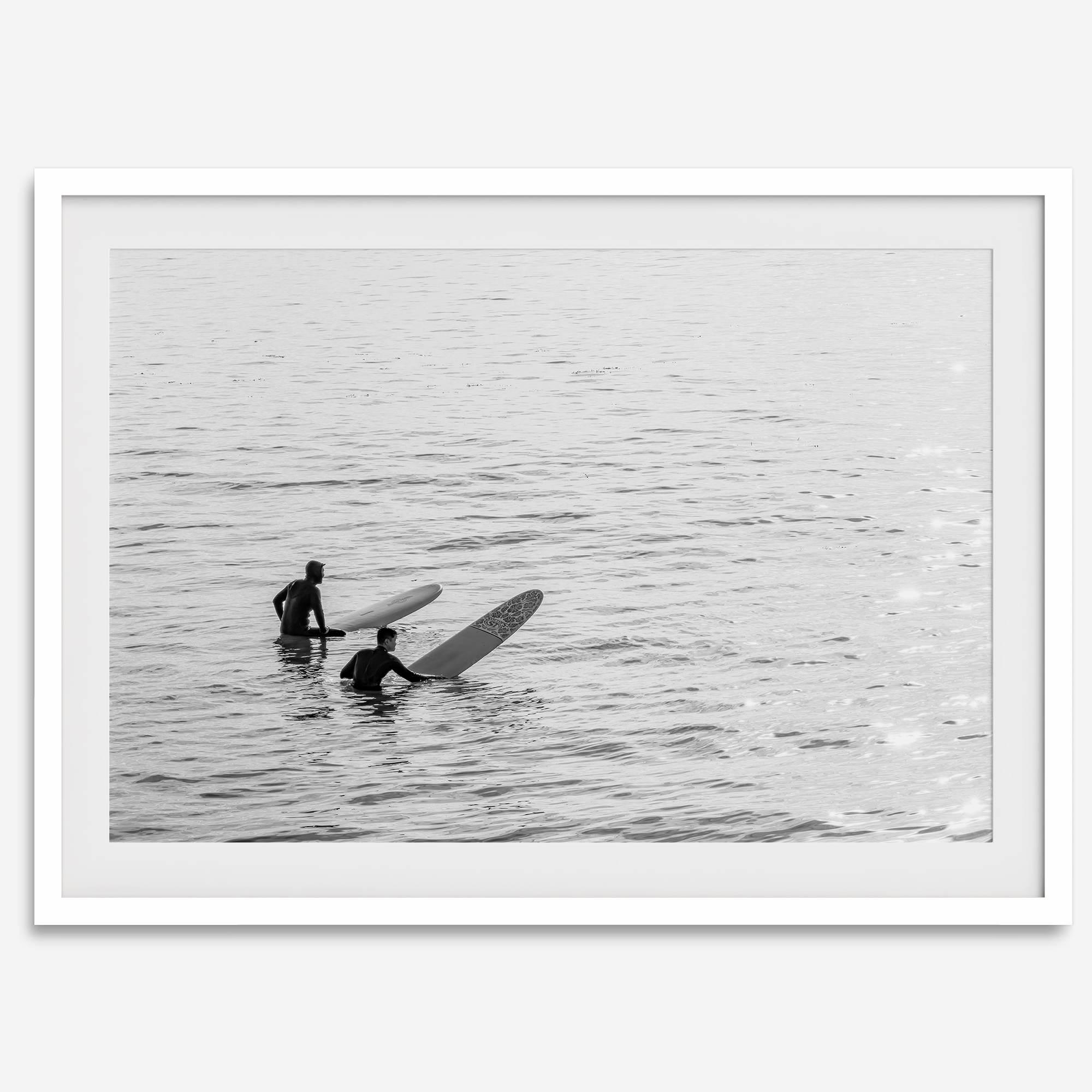 Black and white photo of two surfers with longboards waiting in calm ocean water – fine art surf photography print