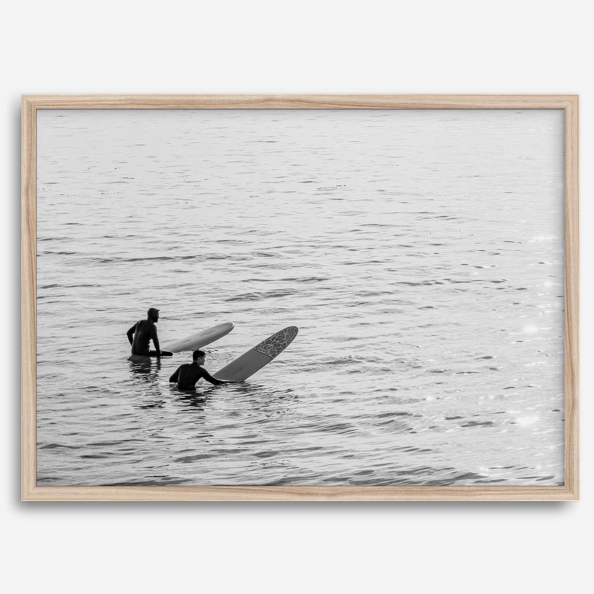 Black and white photo of two surfers with longboards waiting in calm ocean water – fine art surf photography print