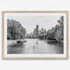 Black and white photo of Lincoln Park, Chicago. A lone rower glides on the park canal with the iconic Willis Tower (formerly Sears Tower) and Chicago skyline in the background.
