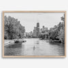 Black and white photo of Lincoln Park, Chicago. A lone rower glides on the park canal with the iconic Willis Tower (formerly Sears Tower) and Chicago skyline in the background.