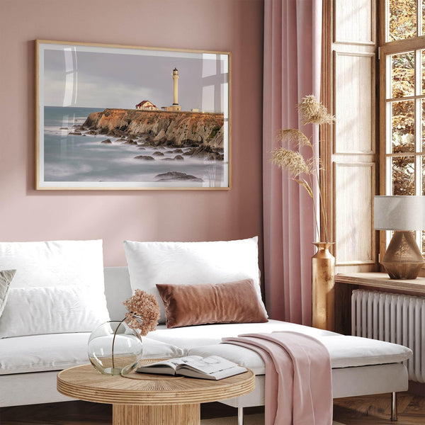 Long exposure fine art photography print of Pigeon Point Lighthouse at sunset. Golden light illuminates the lighthouse and cliffs, while the ocean surf crashes against the rocks in a creamy blur.