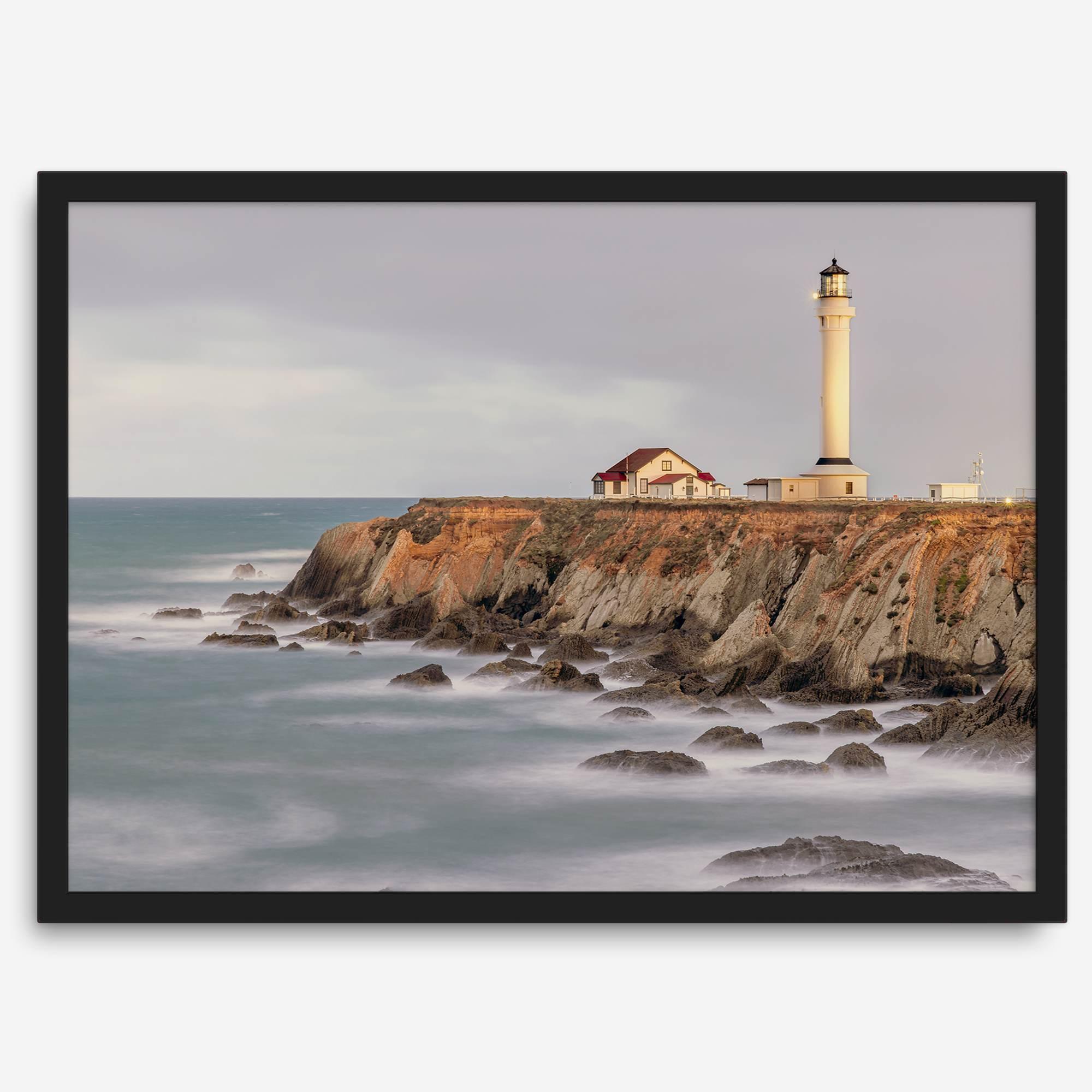 Long exposure fine art photography print of Pigeon Point Lighthouse at sunset. Golden light illuminates the lighthouse and cliffs, while the ocean surf crashes against the rocks in a creamy blur.