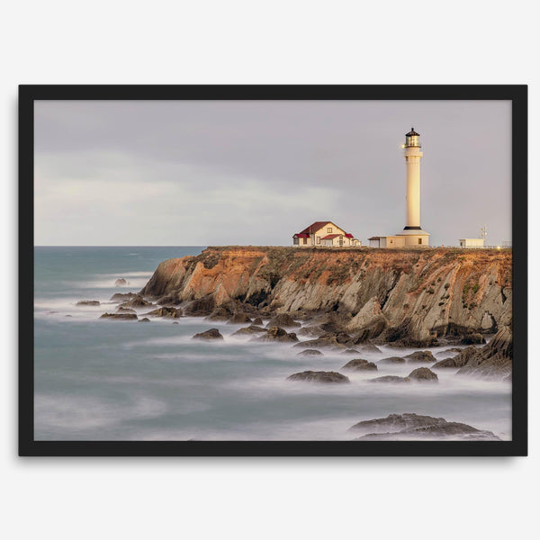 Long exposure fine art photography print of Pigeon Point Lighthouse at sunset. Golden light illuminates the lighthouse and cliffs, while the ocean surf crashes against the rocks in a creamy blur.