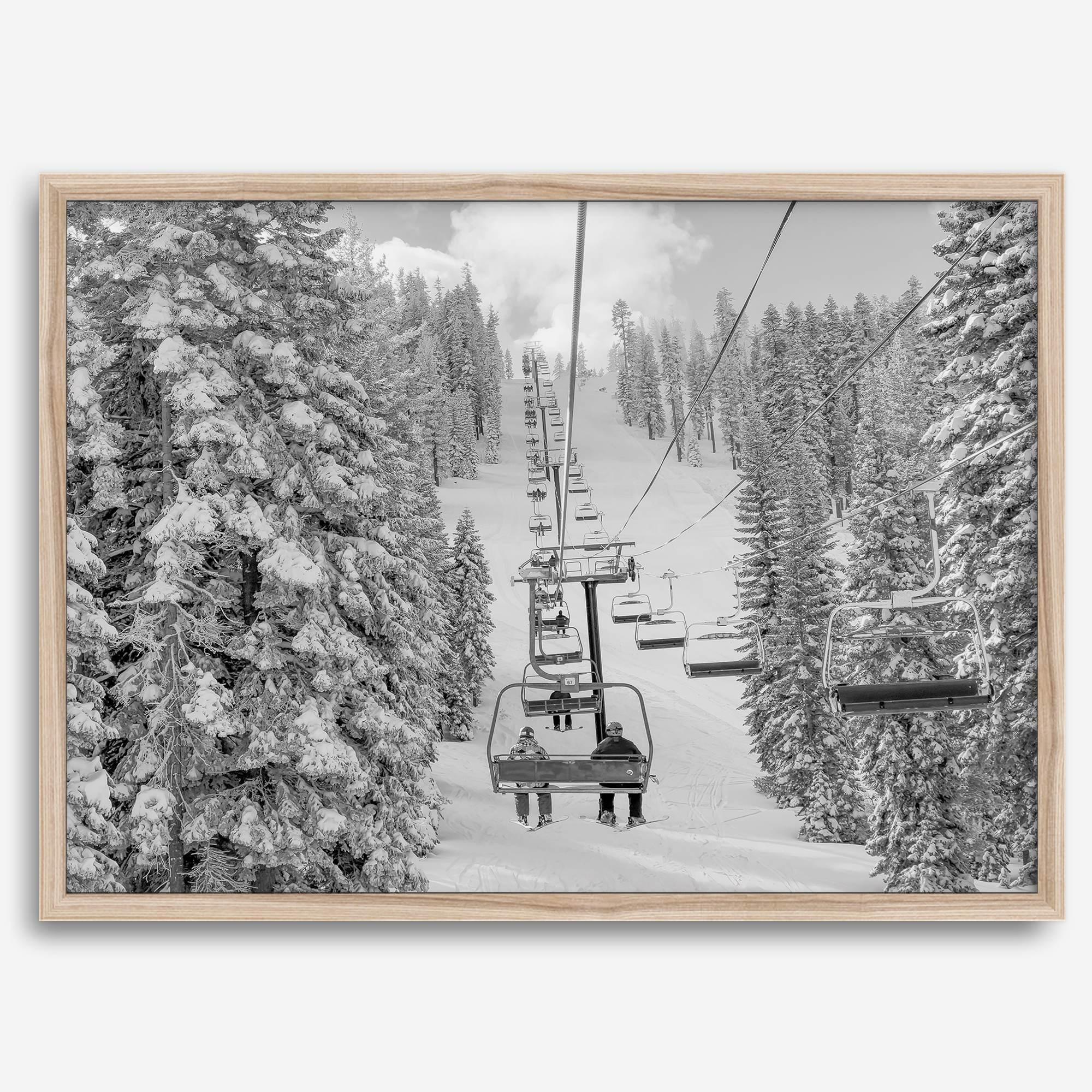 A fine art black and white mountain ski print showing a ski lift winding up the mountain with a stunning winter snow forest around it.