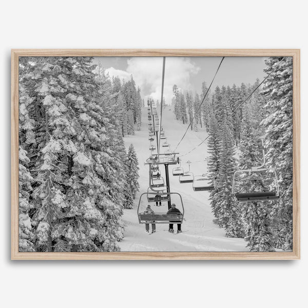 A fine art black and white mountain ski print showing a ski lift winding up the mountain with a stunning winter snow forest around it.