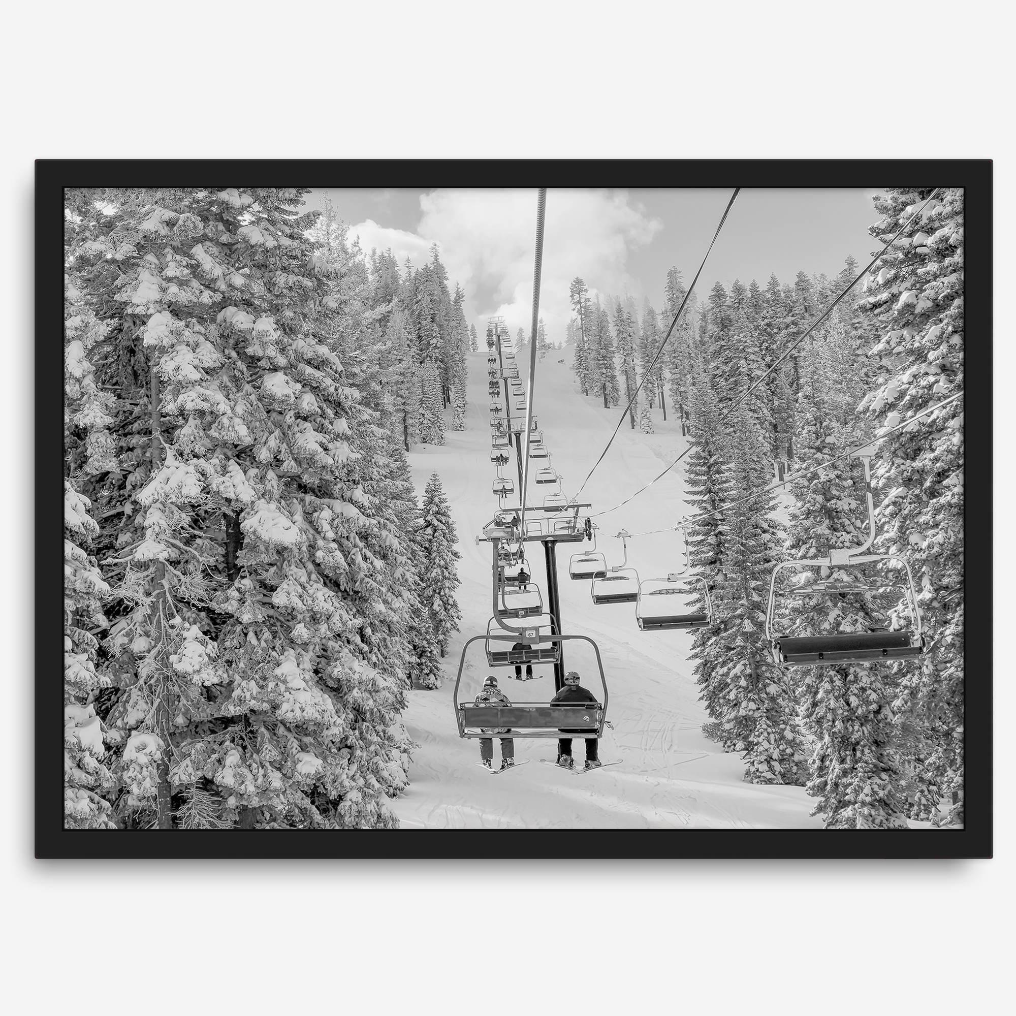 A fine art black and white mountain ski print showing a ski lift winding up the mountain with a stunning winter snow forest around it.
