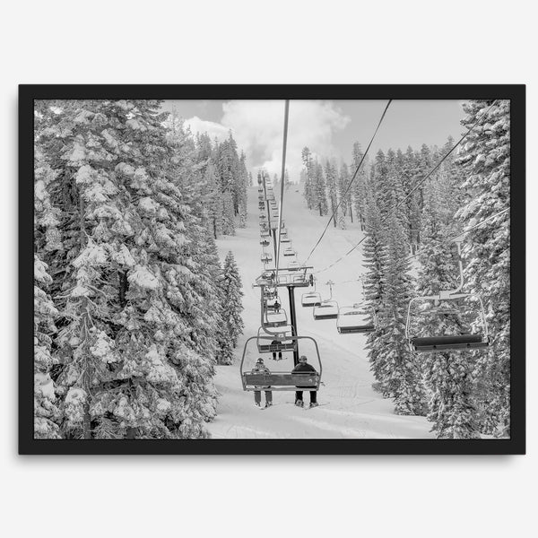 A fine art black and white mountain ski print showing a ski lift winding up the mountain with a stunning winter snow forest around it.