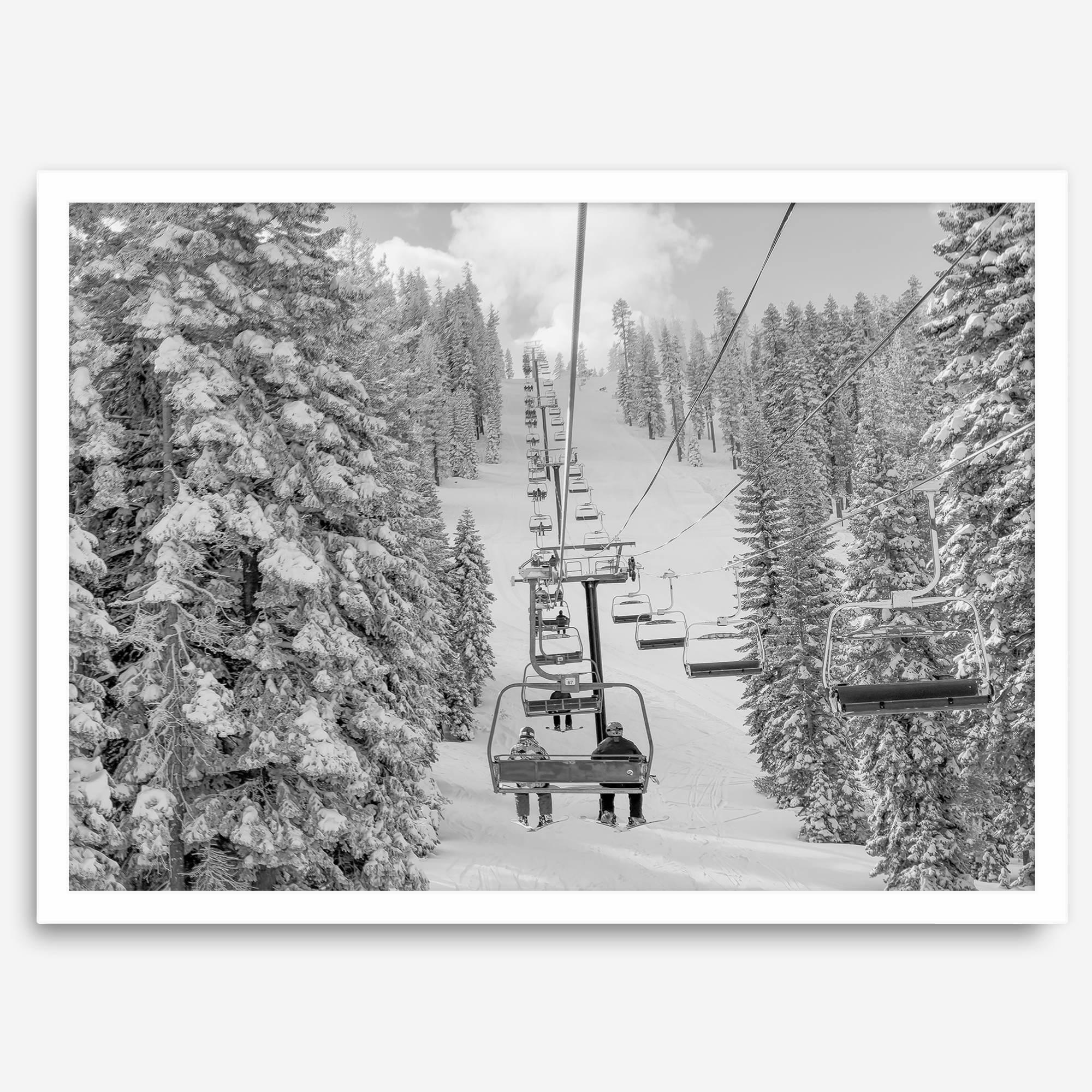A fine art black and white mountain ski print showing a ski lift winding up the mountain with a stunning winter snow forest around it.