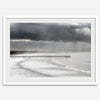 This fine art ocean photography print was taken in Pismo Beach, California, and showcases a distant view of an ocean pier and stormy clouds. Looking long and hard, you can see tens of surfers around the pier.