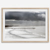 This fine art ocean photography print was taken in Pismo Beach, California, and showcases a distant view of an ocean pier and stormy clouds. Looking long and hard, you can see tens of surfers around the pier.