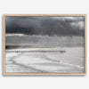 This fine art ocean photography print was taken in Pismo Beach, California, and showcases a distant view of an ocean pier and stormy clouds. Looking long and hard, you can see tens of surfers around the pier.